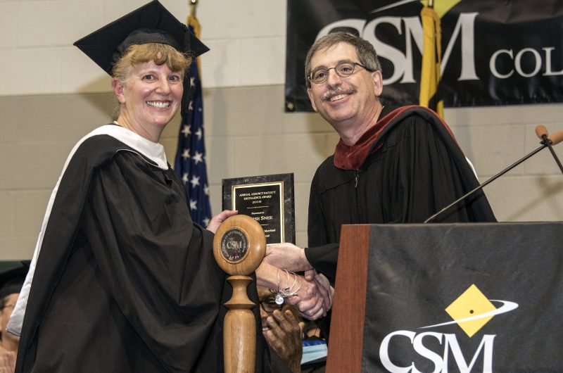 Adjunct Professor of English Denise Snee of La Plata is congratulated by Professor Mike Green after being awarded the Annual Faculty Excellence Award Honoring Adjunct Faculty at the College of Southern Maryland’s 18th Winter Commencement ceremony, held Jan. 19 at the college’s La Plata Campus.