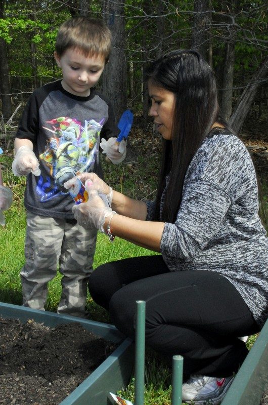Teacher Marietta Wachowski shows preschool student Carson Hood how to plant seeds at St. Charles Children’s Learning Center (CLC) at the College of Southern Maryland at the end of April when the center celebrated Earth Day