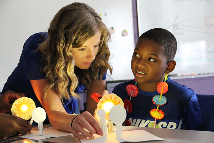 Sherrie Gibney, Discovery Lab Facilitator at the James E. Richmond Science Center, left, and Zion McCoy, a fifth grader at St. Peter’s School, study how a solar eclipse works. The project was one of many highlighted during the Fun in the Sun camp at the James E. Richmond Science Center. 