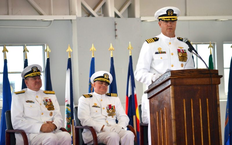 Capt. Jason Hammond, NAS Patuxent River commanding officer, addresses the audience at the NAS Patuxent River change of command ceremony as Rear Adm. Charles Rock, Commandant, Naval District Washington, and Capt. Scott Starkey, former NAS Patuxent River commanding officer, sit behind him Aug. 31. Hammond had served since April 2014 as the air station’s executive officer, a position that falls under the Navy’s Fleet-Up program. In that program, executive officers serve in that position for a year and a half before they “fleet up” to become the commanding officer for their command tour on the same ship or station. (U.S. Navy photo by Donna Cipolloni)