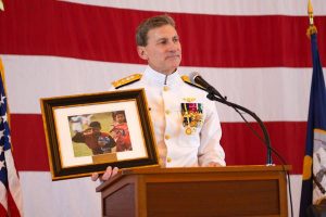 During his speech, Vice Adm. Paul Grosklags pulled from the podium a photo he kept framed in his office for 12 years of two Indonesian children, one of them holding bottles of water and saluting a U.S. Navy helicopter as it departed after delivering relief supplies following the 2004 tsunami that devastated Southeast Asia. The photo exemplified why Grosklags remained in the Navy for 36 years. (U.S. Navy photo)