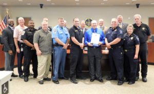 Armorer Jeff McLane, (right in blue) is joined by his colleagues of the St. Mary's County Sheriff's Office as the Commissioners of St. Mary's County thank him for 41 years of service and counting.